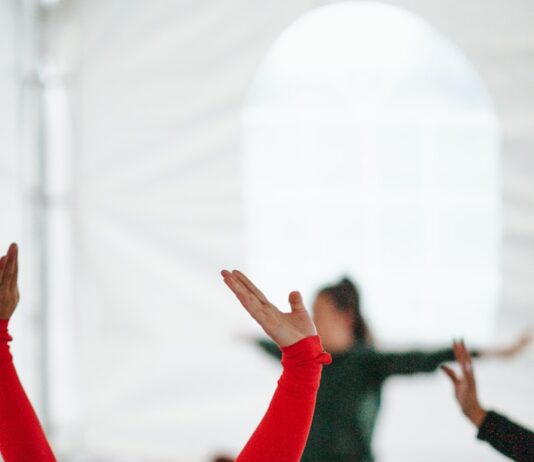 간단한 스트레칭으로 몸 풀기 woman in red long sleeve shirt raising her hands