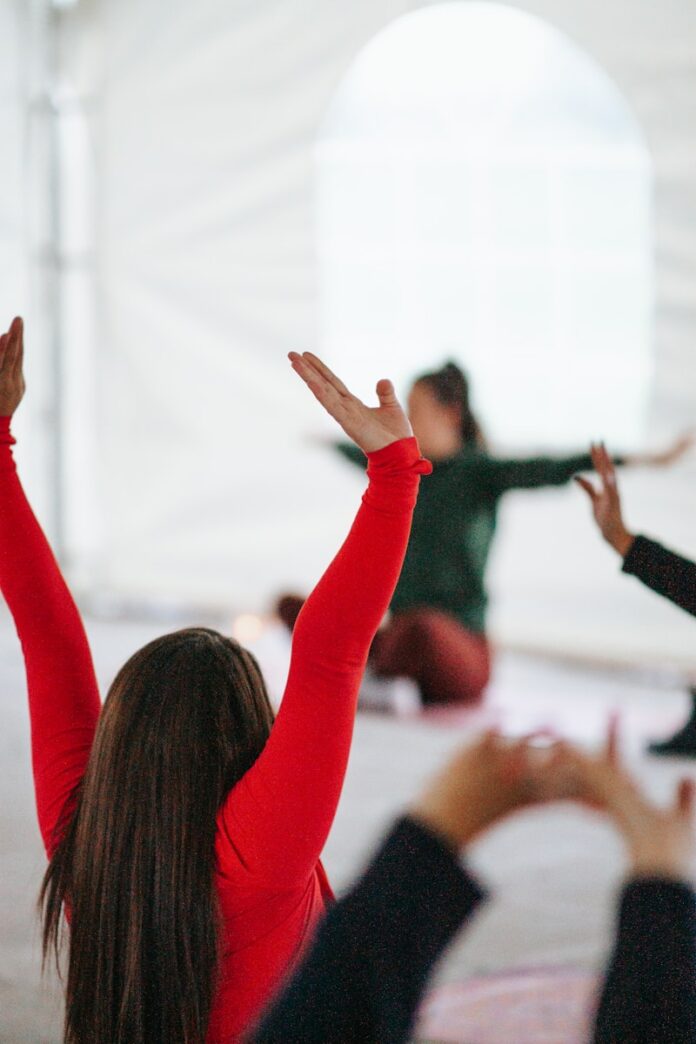 Photo by Shayna Douglas woman in red long sleeve shirt raising her hands