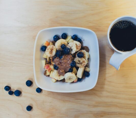 음식의 질이 건강에 미치는 영향 sliced bananas with berries and peanut butter beside cup of coffee on table
