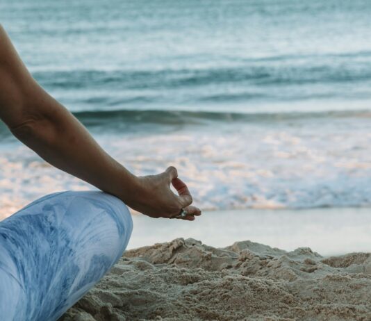 명상의 효과: 집중력과 스트레스 감소 person in blue shorts sitting on beach shore during daytime