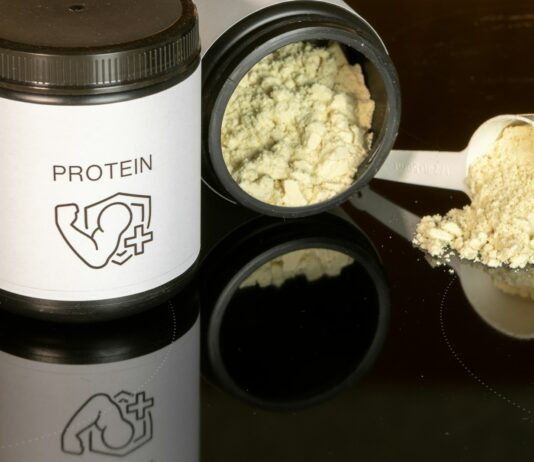 단백질 보충제의 효과적인 섭취 시점 a jar of protein powder next to a spoon